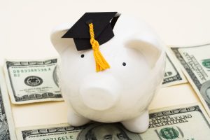 A,Piggy,Bank,Wearing,A,Graduation,Cap,With,Hundred,Dollar